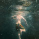 Atmospheric painting of a boy immersed in dark water.