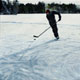 Painting of skater with hockey stick on northern lake
