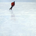 Painting of skater on vast expanse of white ice